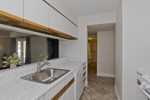 kitchen featuring a sink, white cabinetry, baseboards, range, and dishwasher