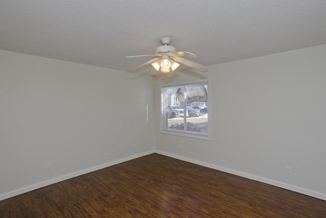 spare room with a ceiling fan, dark wood finished floors, a textured ceiling, and baseboards