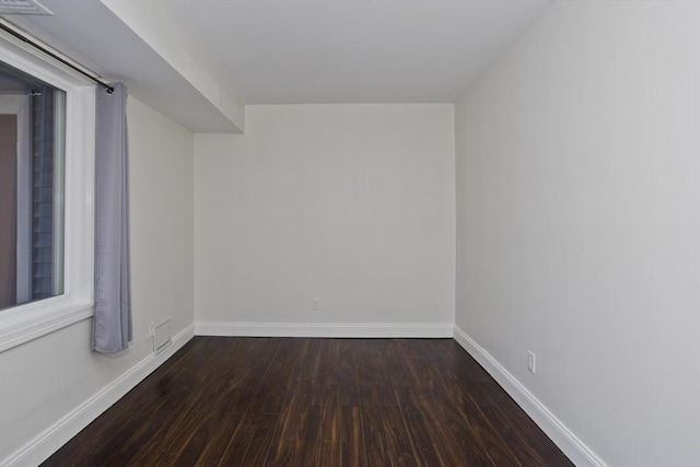 unfurnished room with visible vents, baseboards, and wood finished floors