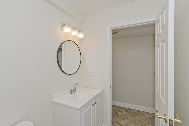 half bath featuring visible vents, vanity, and baseboards