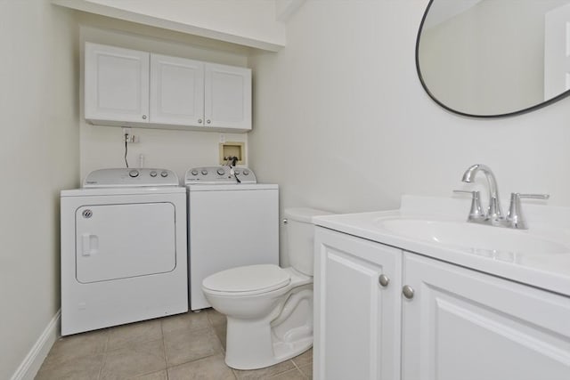 bathroom with toilet, vanity, baseboards, washer and dryer, and tile patterned floors