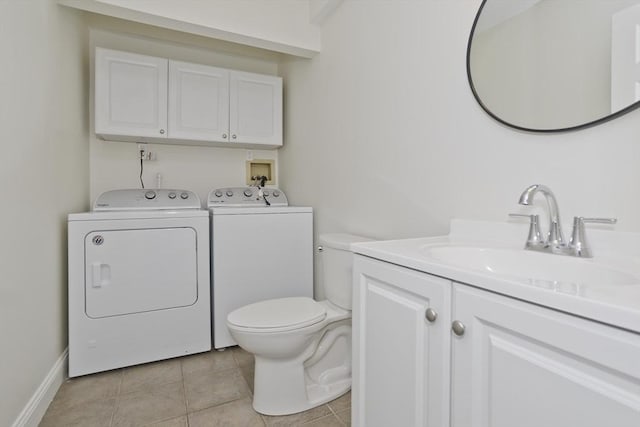 bathroom with washer and clothes dryer, toilet, vanity, tile patterned flooring, and baseboards