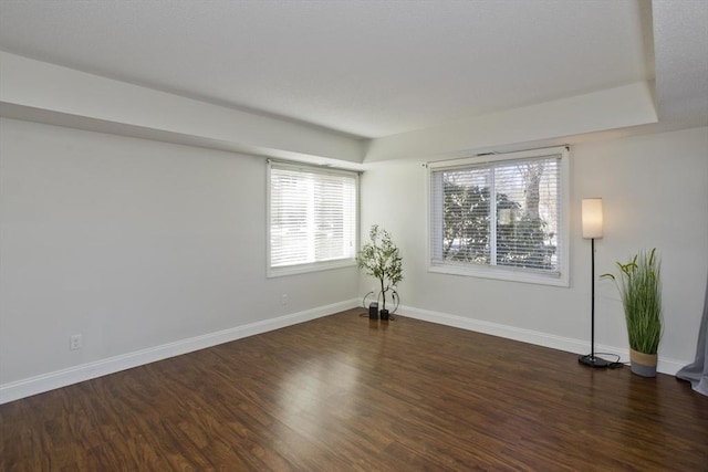 spare room featuring wood finished floors and baseboards