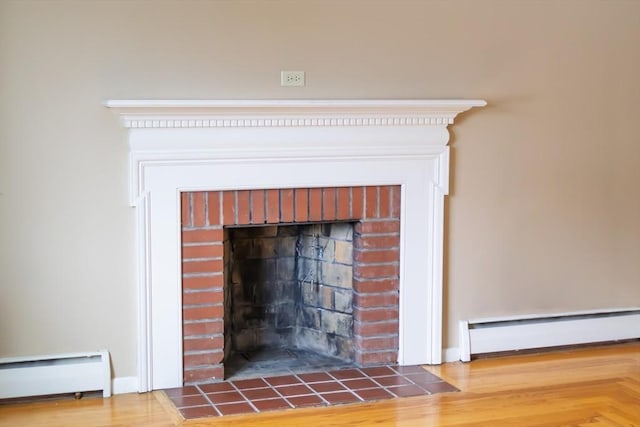 interior details featuring a baseboard heating unit, a fireplace, and baseboard heating