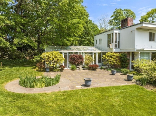 back of house with a patio area, a chimney, and a yard