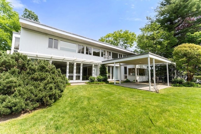 rear view of house featuring a yard and a patio