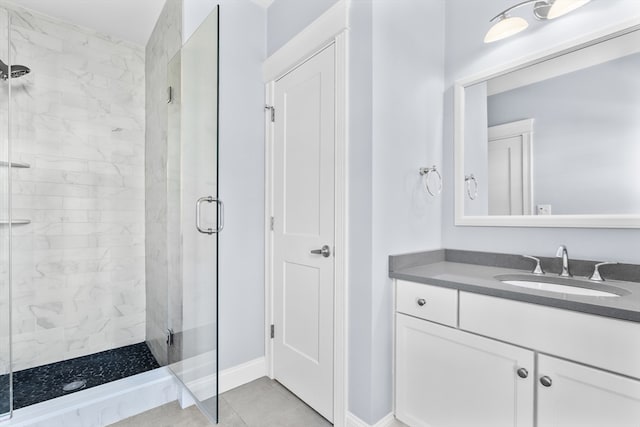 bathroom featuring a shower with door, vanity, and tile patterned flooring