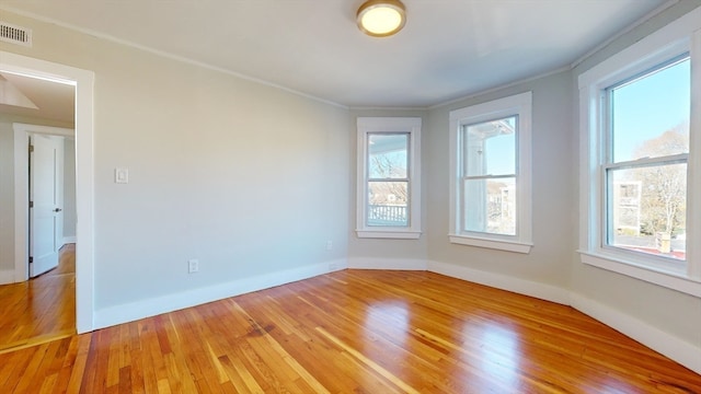 empty room featuring hardwood / wood-style floors and crown molding