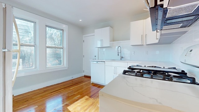 kitchen with backsplash, white appliances, exhaust hood, light hardwood / wood-style floors, and white cabinetry