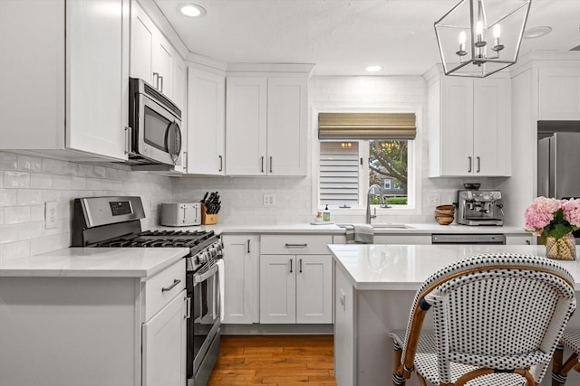 55 Rosemont Rd, Weymouth, MA 02191 - kitchen with appliances with stainless steel finishes, light countertops, white cabinets, wood finished floors, and recessed lighting