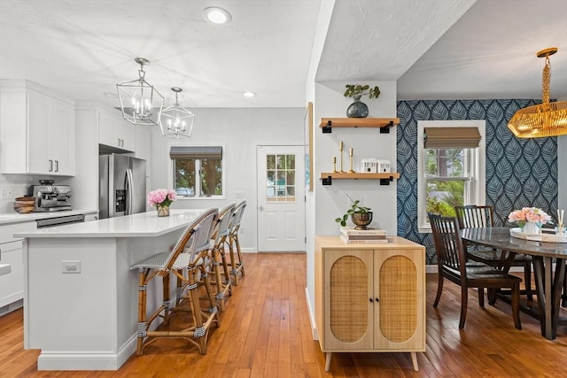 55 Rosemont Rd, Weymouth, MA 02191 - kitchen with stainless steel fridge with ice dispenser, a chandelier, light countertops, a center island, and white cabinets