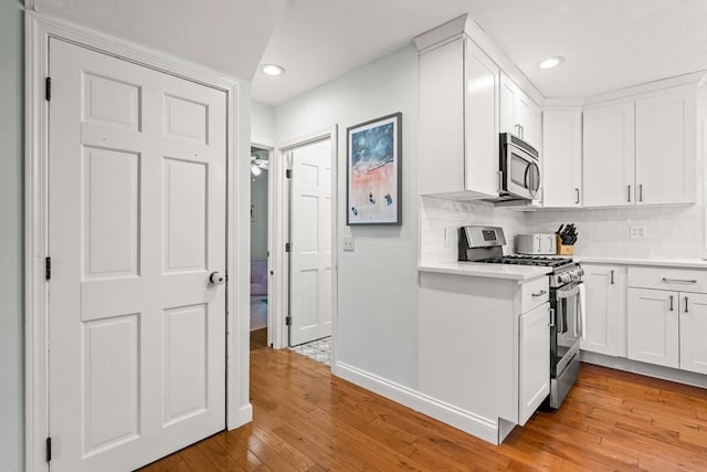 55 Rosemont Rd, Weymouth, MA 02191 - kitchen featuring appliances with stainless steel finishes, light countertops, light wood-style floors, recessed lighting, and white cabinetry