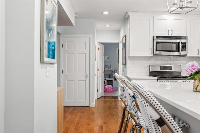 55 Rosemont Rd, Weymouth, MA 02191 - kitchen with stainless steel appliances, light countertops, white cabinets, light wood finished floors, and recessed lighting