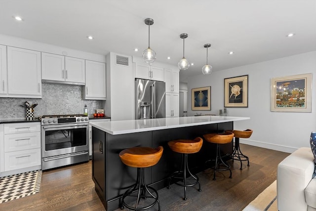 kitchen with stainless steel appliances, visible vents, white cabinets, decorative backsplash, and dark wood finished floors