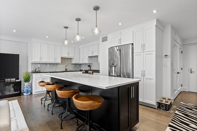 kitchen with appliances with stainless steel finishes, dark wood finished floors, visible vents, and white cabinetry