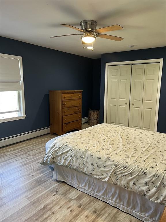 106 Shaw Rd, Goshen, MA 01330 - bedroom featuring a closet, light wood-style flooring, baseboard heating, baseboards, and ceiling fan