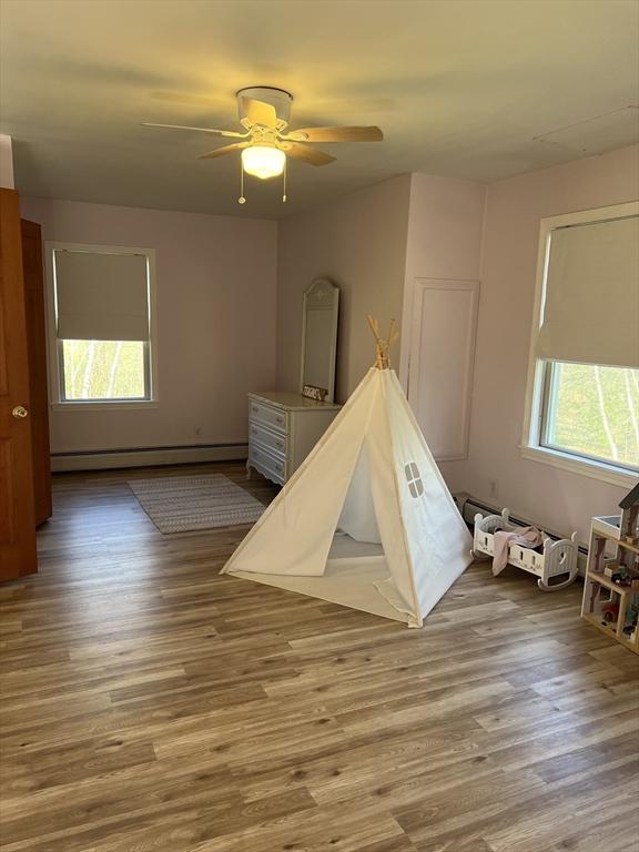 106 Shaw Rd, Goshen, MA 01330 - recreation room featuring a baseboard heating unit, wood finished floors, and a ceiling fan