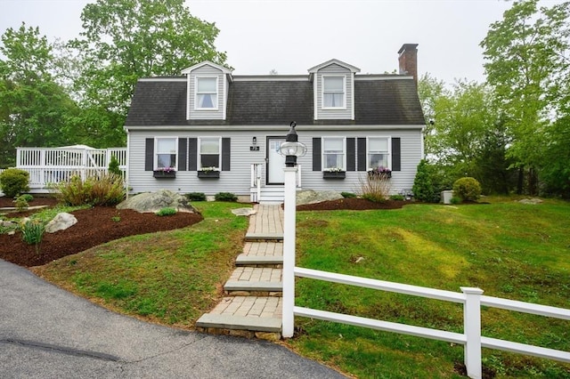 view of front of house with a chimney and roof with shingles