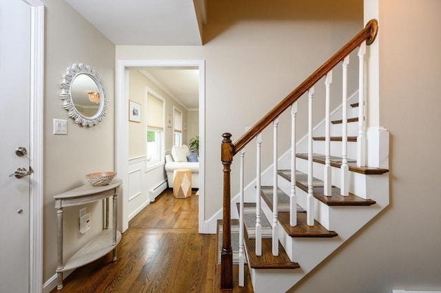 staircase featuring a baseboard radiator, wood finished floors, and baseboards