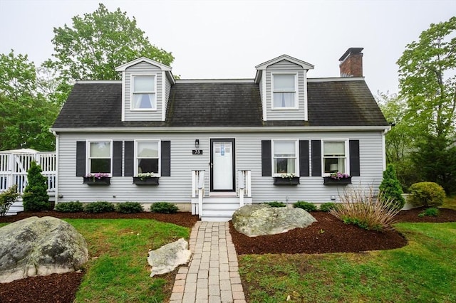 cape cod home with a chimney and a front yard