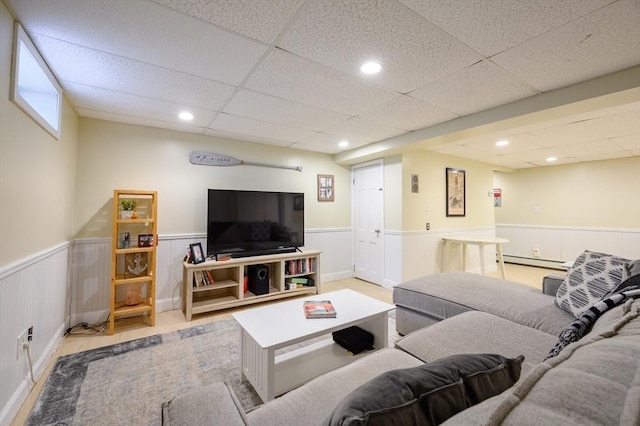living room featuring a wainscoted wall, a baseboard heating unit, a drop ceiling, and recessed lighting