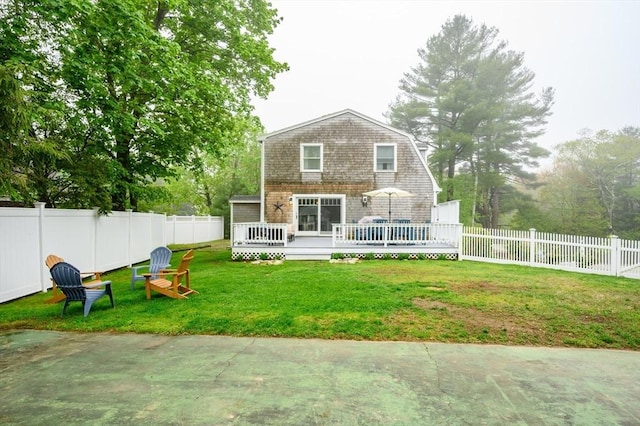 rear view of house with a wooden deck and a gambrel roof