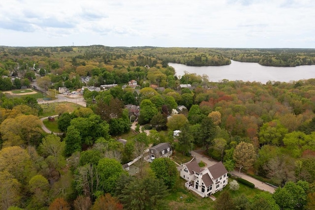view of property location with a large body of water and a heavily wooded area