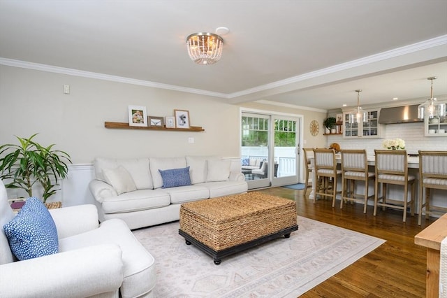 living area featuring a chandelier, wood finished floors, and ornamental molding