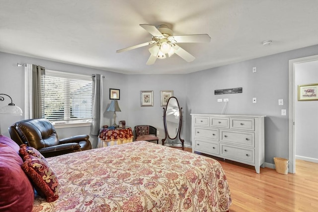 bedroom with light wood-style floors, baseboards, and a ceiling fan