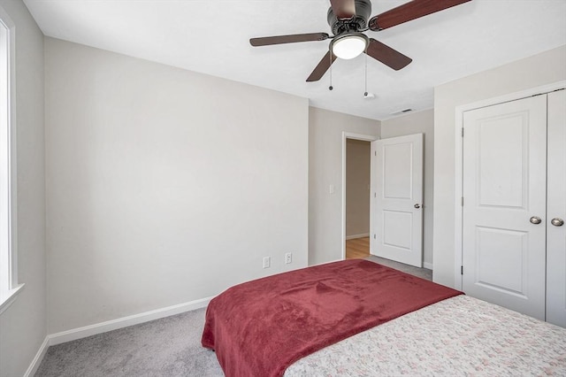 bedroom with ceiling fan, baseboards, and light colored carpet