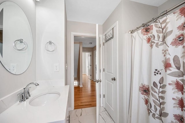 bathroom featuring marble finish floor, vanity, and a shower with curtain