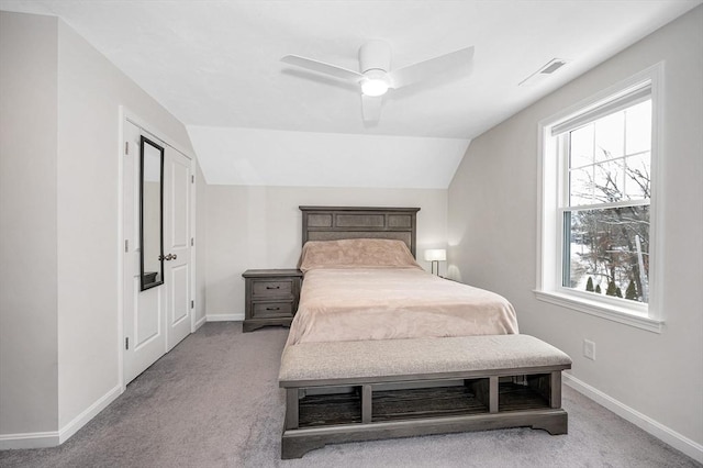 bedroom featuring lofted ceiling, baseboards, visible vents, and light colored carpet