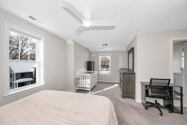 carpeted bedroom featuring a ceiling fan, visible vents, and baseboards