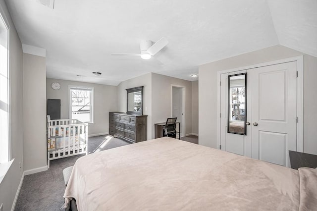 bedroom with ceiling fan, baseboards, vaulted ceiling, a closet, and dark carpet