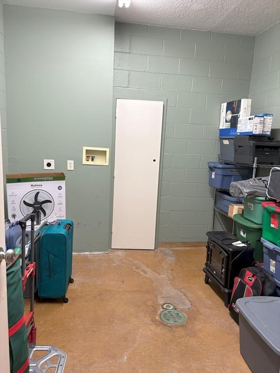 48 Phillips Rd Unit 17, Holden, MA 01520 - washroom featuring concrete block wall and a wood stove