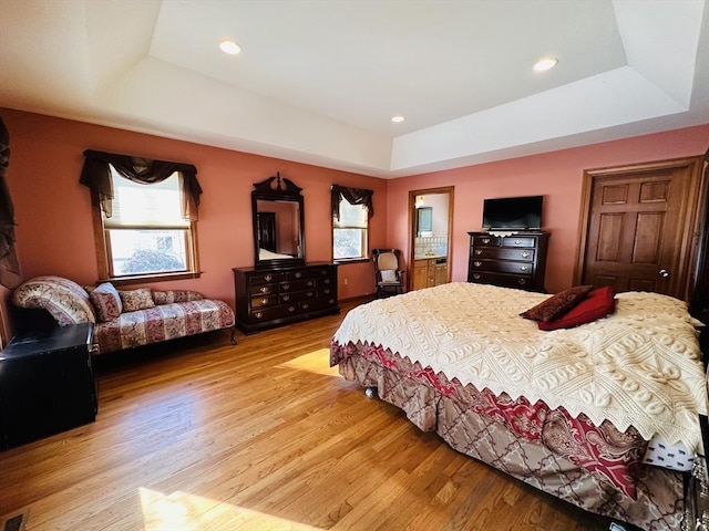 bedroom with multiple windows and a raised ceiling