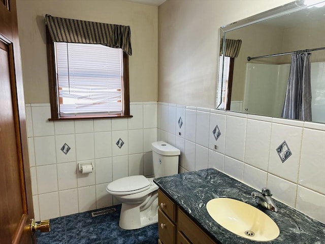 full bath with toilet, curtained shower, plenty of natural light, and vanity