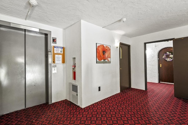875 John Fitch Hwy Unit 23, Fitchburg, MA 01420 - corridor with carpet flooring, elevator, a textured ceiling, and arched walkways