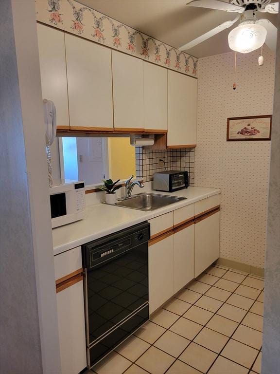 kitchen featuring decorative backsplash, light tile patterned floors, white cabinetry, and black dishwasher