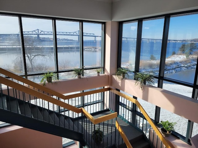 sunroom featuring a water view