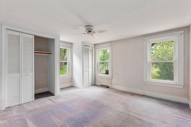 1123 E St, Ludlow, MA 01056 - unfurnished bedroom with two closets, carpet, ceiling fan, and baseboards