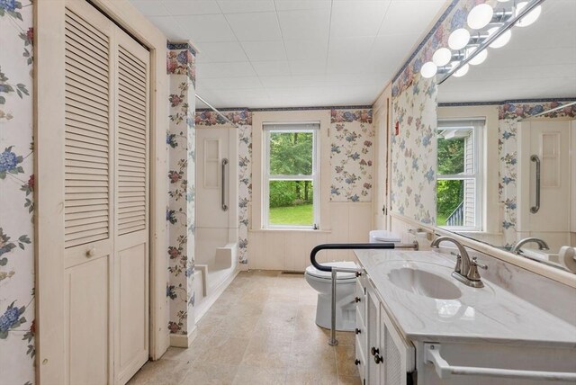 1123 E St, Ludlow, MA 01056 - bathroom with wallpapered walls, a wainscoted wall, toilet, vanity, and a closet