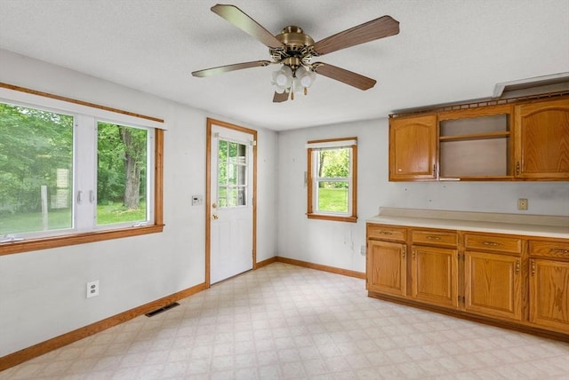 1123 E St, Ludlow, MA 01056 - kitchen with baseboards, brown cabinetry, light floors, and light countertops