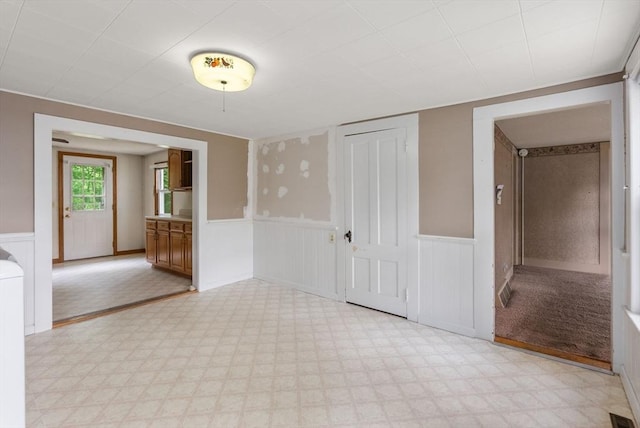 1123 E St, Ludlow, MA 01056 - empty room with a wainscoted wall, light floors, and a decorative wall
