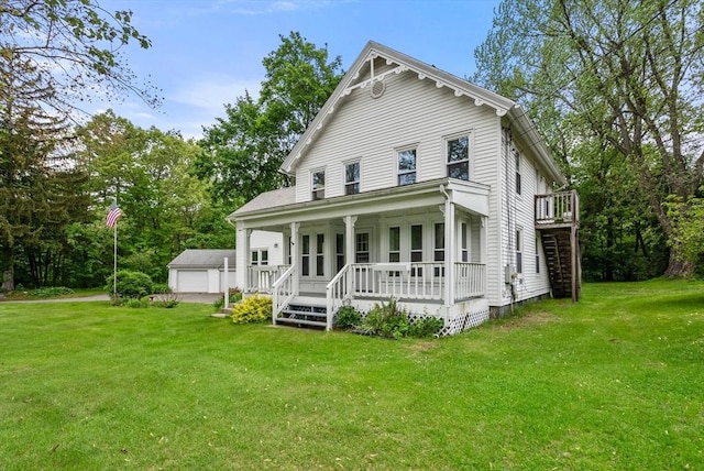 1123 E St, Ludlow, MA 01056 - view of front of property featuring a porch, a front lawn, a detached garage, stairs, and an outbuilding