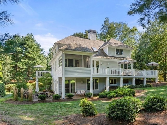 rear view of house featuring a yard, a pergola, a sunroom, and a patio