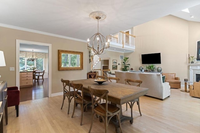 dining area featuring ornamental molding, a chandelier, and light hardwood / wood-style floors