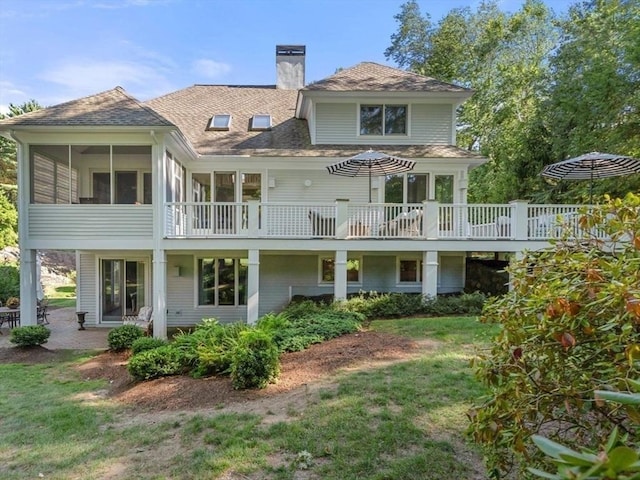 rear view of house with a sunroom and a lawn