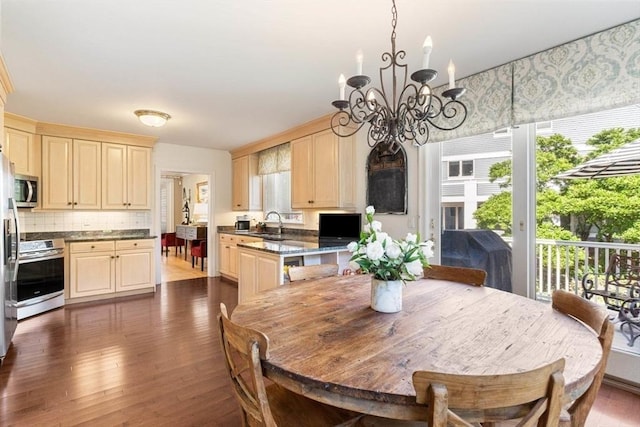 dining area featuring a healthy amount of sunlight, dark wood-type flooring, and a chandelier