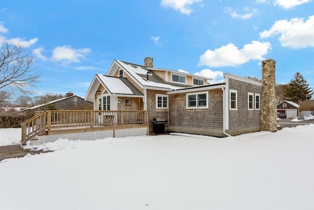 snow covered house featuring a deck